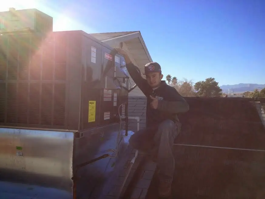 HVAC technician performing Heat Pump Repair on a rooftop unit in Northampton
